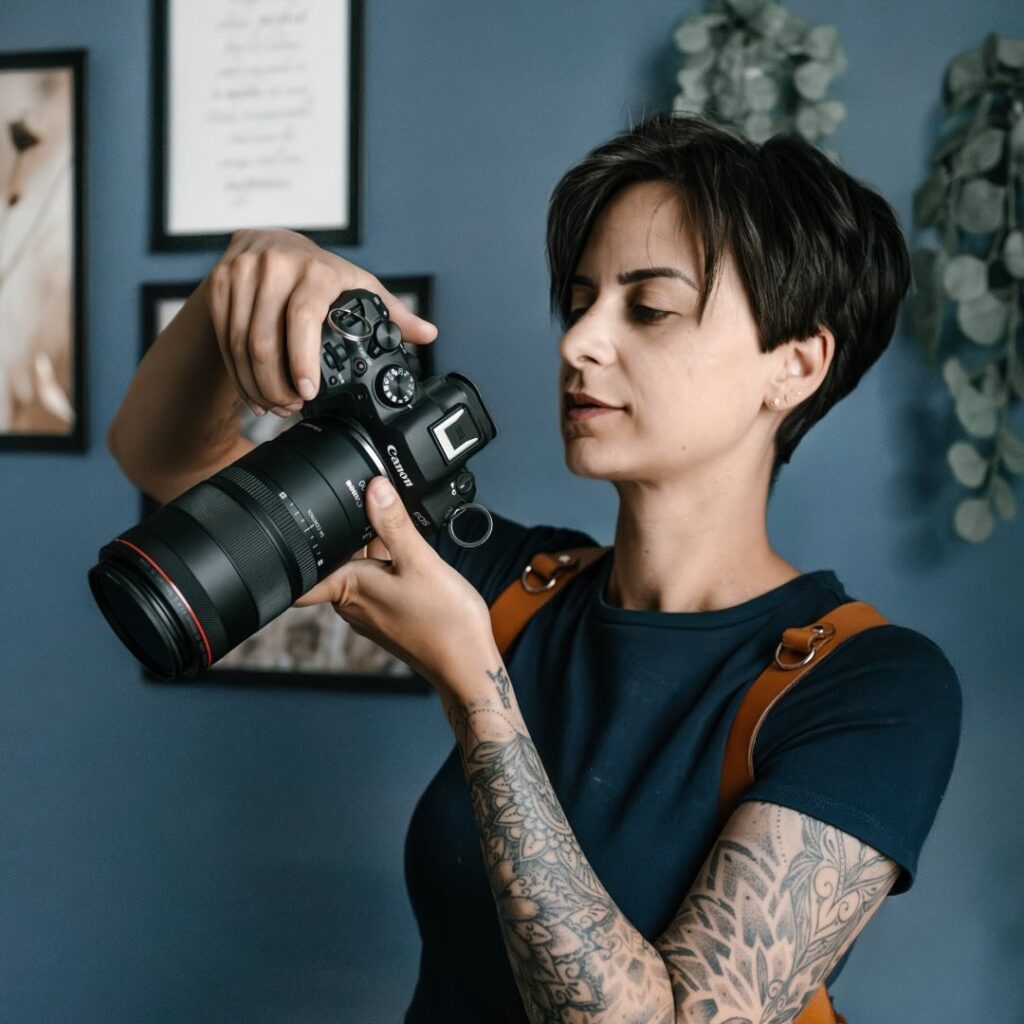 Portrait de Mélissa Mania, photographe professionnelle, ajustant son appareil photo dans un décor moderne et élégant.